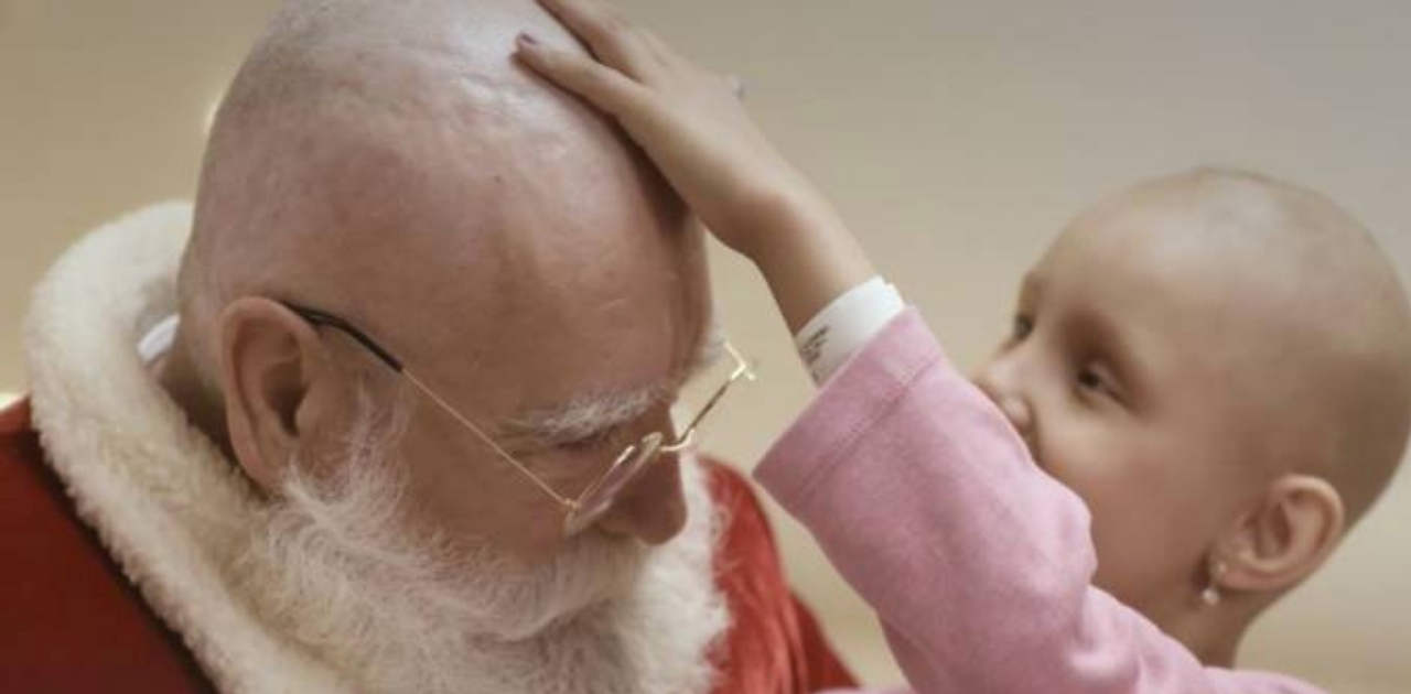 Papai Noel rapa o cabelo durante visita a crianças que lutam contra o câncer