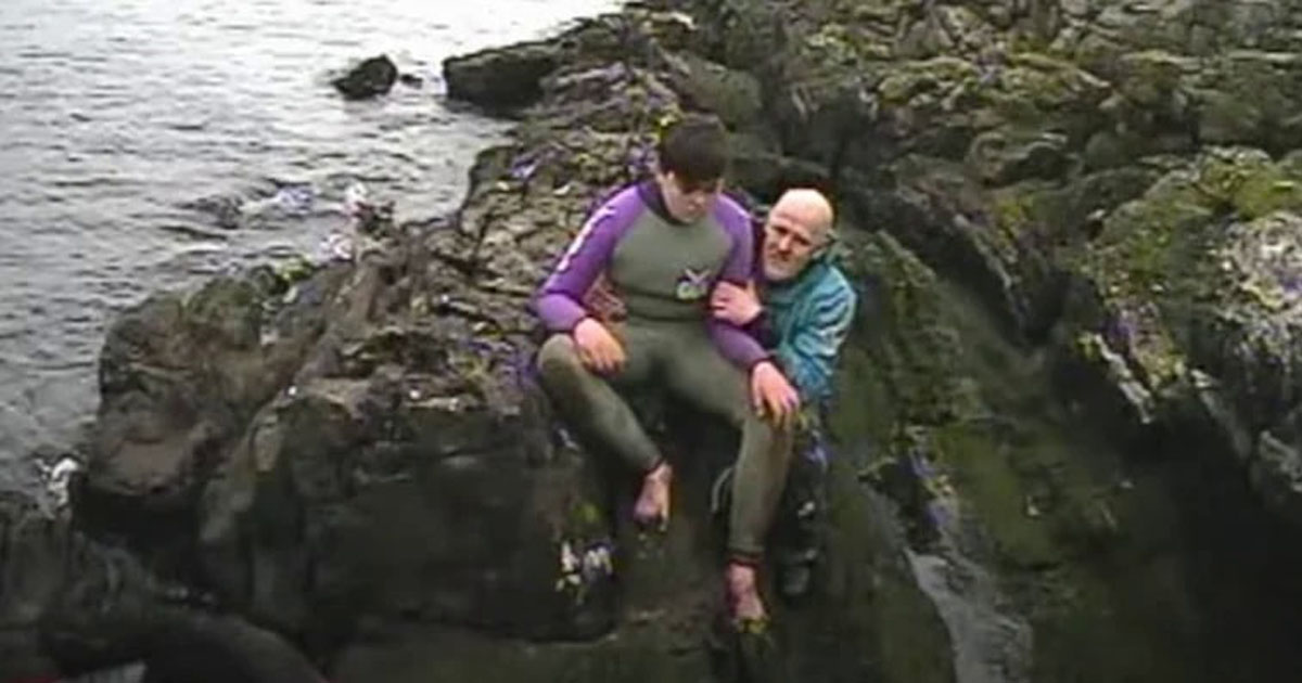 pai e filho sentados rocha ilha