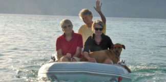 Três mulheres em barco com cachorro