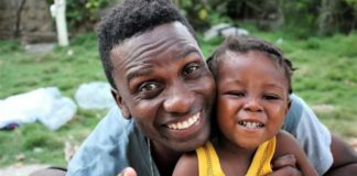 Haitiano de 22 anos encontra bebê abandonado em lata de lixo e decide adotá-lo