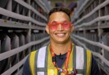 funcionário da amazon usa óculos em formato de estrela e sorri