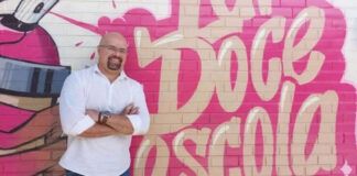 diretor de escola em frente a muro grafitado