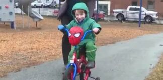 menino anda de bicicleta com ajuda da mãe