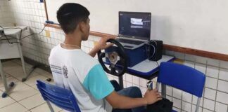 estudante manuseia simulador de corridas de carro feito com materiais recicláveis