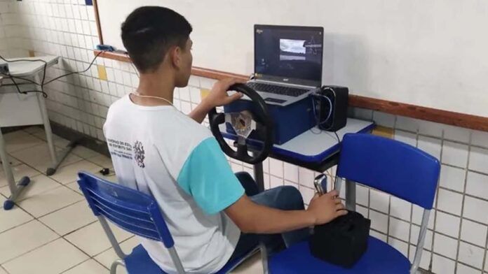 estudante manuseia simulador de corridas de carro feito com materiais recicláveis